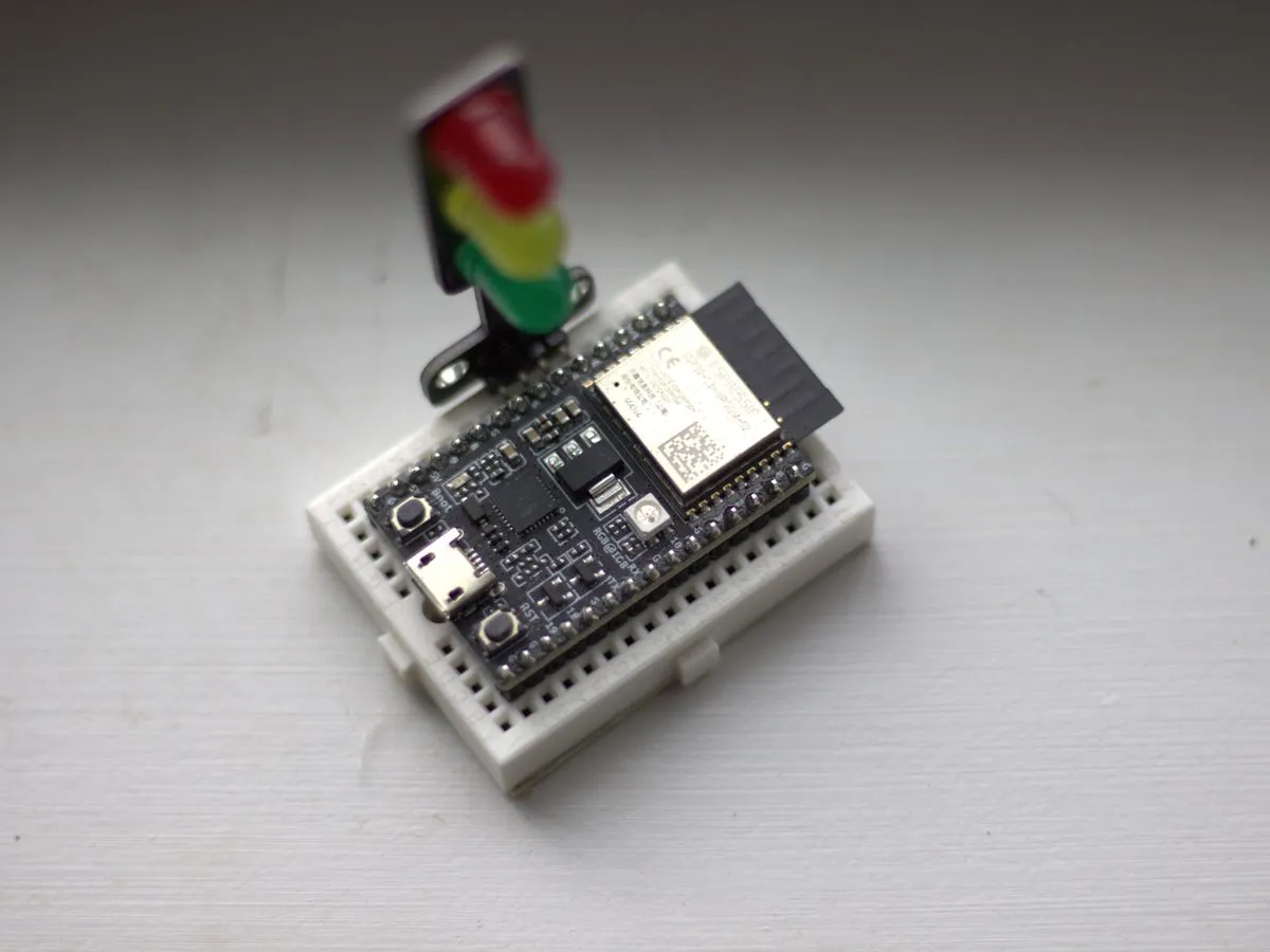 Placa ESP32 montada en una mini protoboard con un módulo de semáforo de LEDs