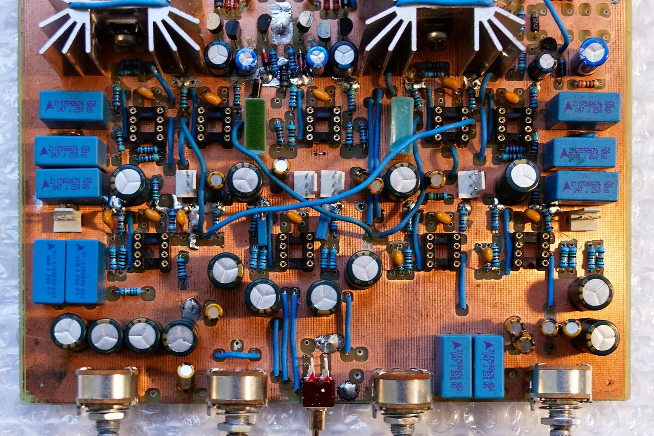 Placa de circuito impreso de fabricación casera, con condensadores, disipadores y potenciómetros soldados