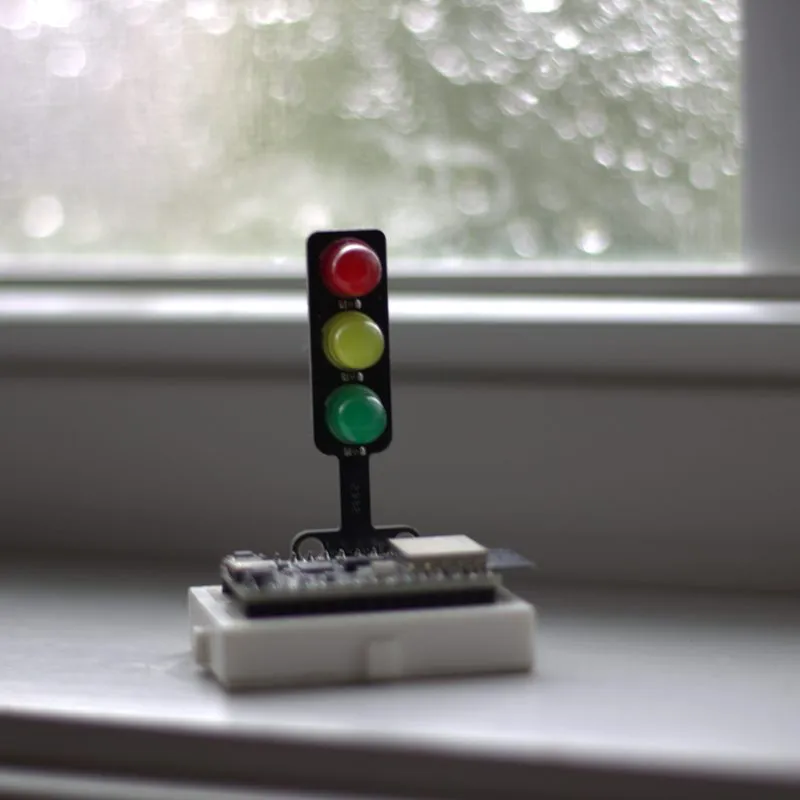 Semáforo de LEDs sobre una placa en el marco de una ventana